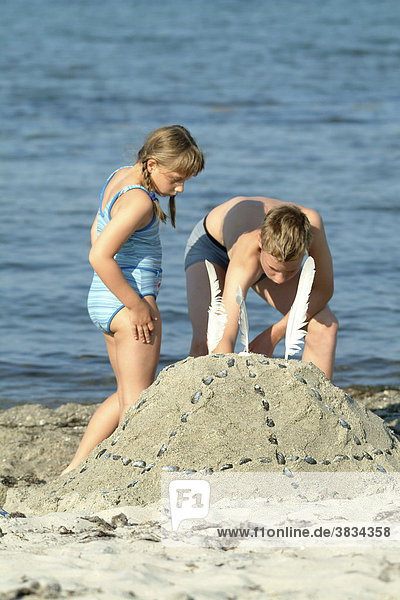 Junge und maedchen spielt am strand