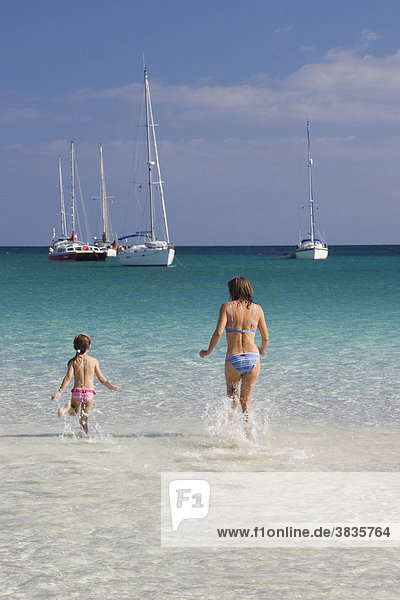 Frau und Kind laufen im Wasser am Strand Cala Brandinchi Ostküste Sardinien