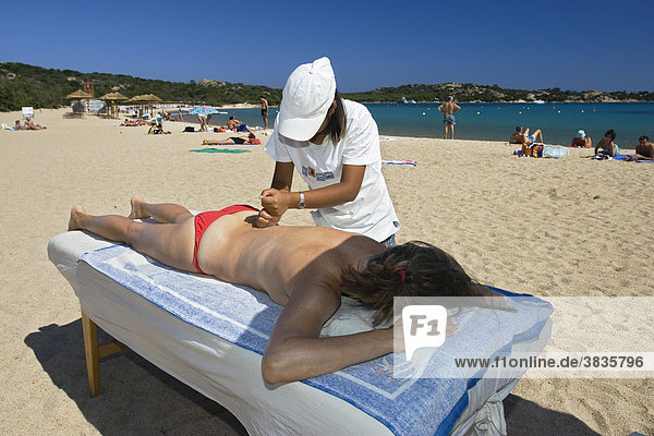 Chinesin massiert Frau am Strand  Costa Smeralda Sardinien