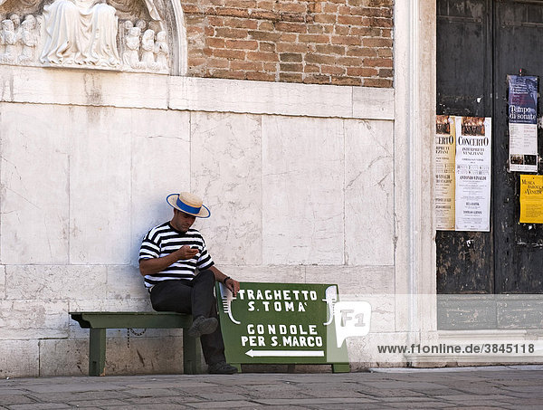 Gondolier sitting on a bench for gondoliers  waiting for customers  sign for gondolas in Venice  Veneto  Italy  Europe