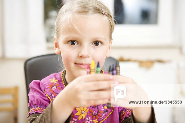 A girl showing her wax crayons