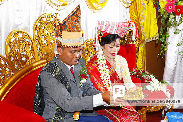 Bride and groom with food  wedding ceremony  Siantar  Batak region  Sumatra  Indonesia  Asia
