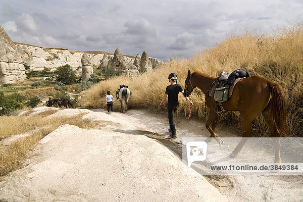 Riders with horses walking through the tufa landscape of the UNESCO World Heritage Site Goreme  Cappadocia  central Anatolia  Turkey  Asia