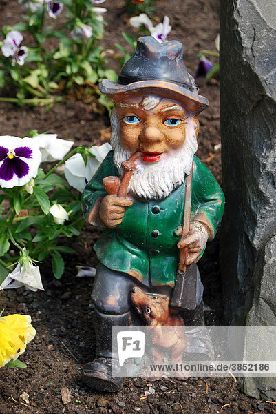 Garden gnome smoking woodman with a pipe Dachshund and rifle
