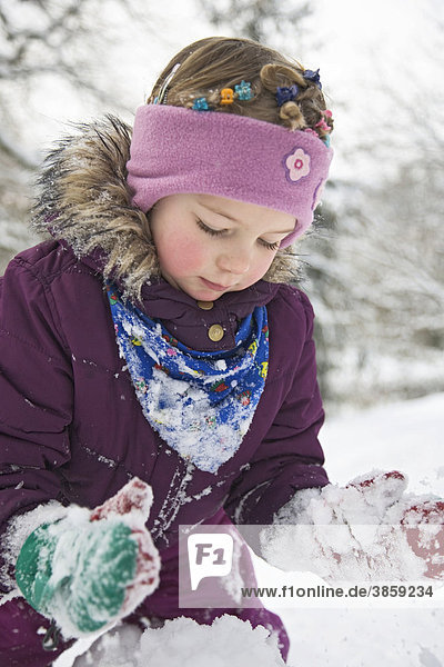 Kleines Mädchen spielt im Schnee
