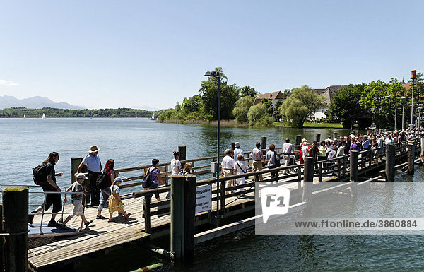 Tourists on the Fraueninsel pier disembarking and waiting to board a ferry  lake Chiemsee  Chiemgau  Upper Bavaria  Germany  Europe