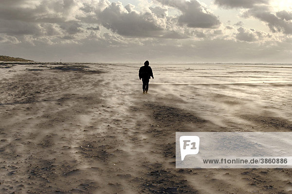 Einsame Gestalt bei starkem Wind am Strand,  Insel Juist,  Niedersachsen,  Norddeutschland,  Deutschland,  Europa