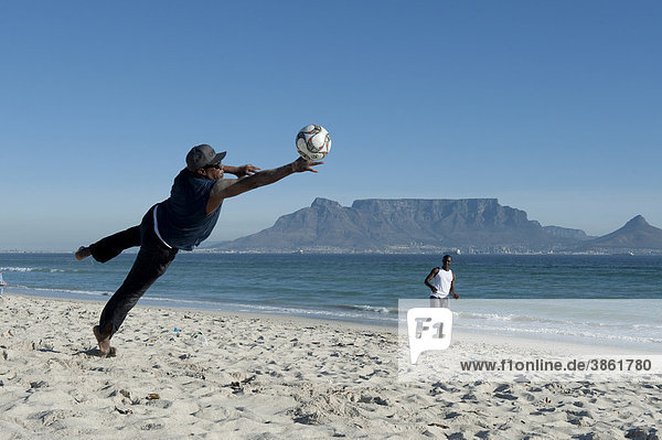 Men playing football on the beach in Bloubergstrand  Table Mountain at back  Cape Town  Western Cape  South Africa  Africa