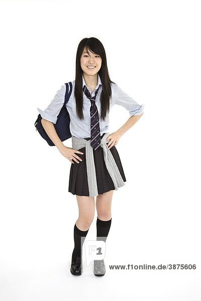 Portrait Of A Female Asian Teenager Dressed In The Traditional Japanese Schoolgirl Clothing Uniforms Are Worn By Most Of The Female School Children In Japan She Is Standing On A White Background