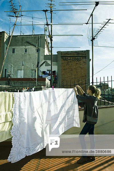 Teenager Mädchen hängen Wäsche zum Trocknen auf dem Dach Wäscheleine