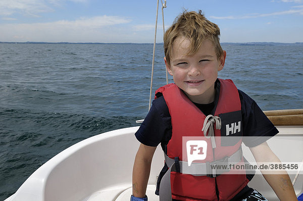 6jähriger Junge mit Schwimmweste sitzt auf einem Boot  Gardasee  Italien  Europa