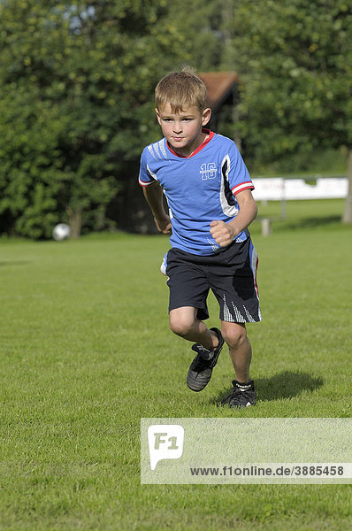 6-year-old boy running across a football field  Egmating  Kreis Ebersberg district  Upper Bavaria  Bavaria  Germany  Europe