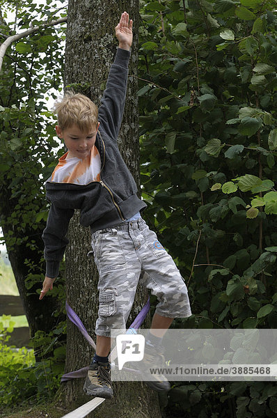 6jähriger Junge balanciert über einen Spanngurt  Oberbayern  Bayern  Deutschland  Europa