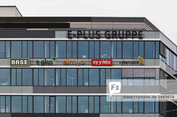Moderne Glasfassade des Hauptsitzes der E-Plus Gruppe in Düsseldorf  darunter die Logos von Base  E-plus  simyo  ay yildiz und vybemobile  Mobilfunk  Deutschland  Europa