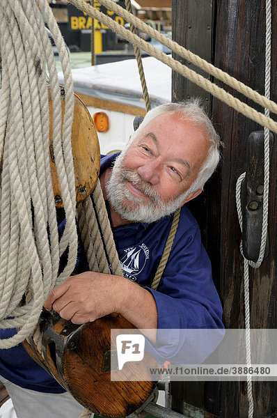 Seemann mit Seil und Talje auf einem alten Segelschiff