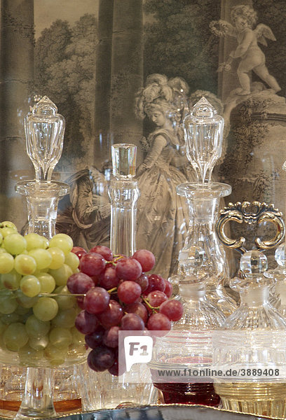 Still Life with grapes in fine  stylish glasses in front of antique glass decanters in a luxurious ambience