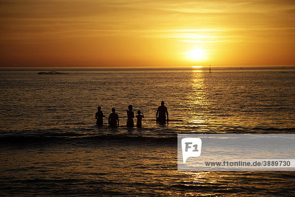 Sunset and swimmers on Glenelg beach  Adelaide  South Australia  Australia
