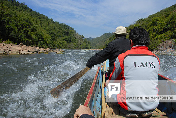 Wooden boat with a paddle going upstream the Nam Ou River  wild river  at Hathinh  Phou Den Din National Protected Area  Phongsali district and province  Laos  Southeast Asia  Asia