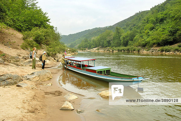 Tourists on the shore  river valley  wooden boat on the Nam Ou river in Muang Khoua  Phongsali province  Laos  Southeast Asia  Asia