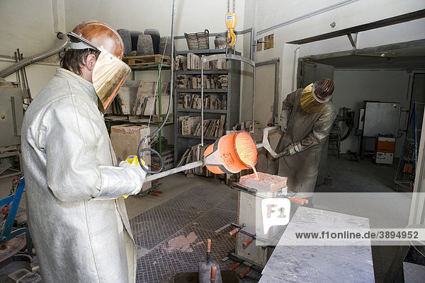 Working in an art foundry  liquid bronze being poured into moulds