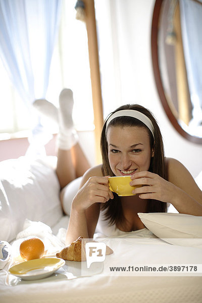 Frau bei Frühstück im Bett