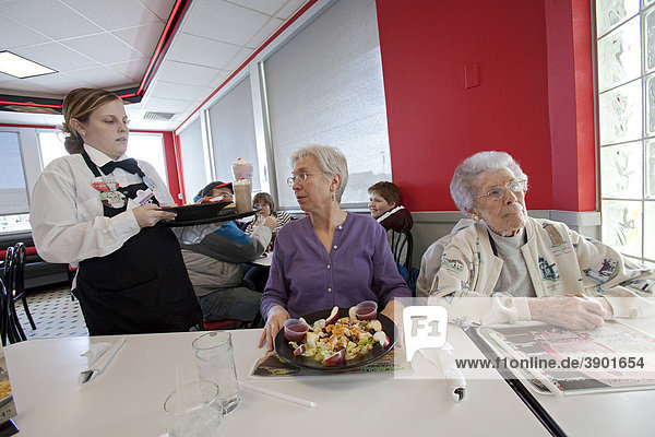 Eine Kellnerin serviert zwei älteren Damen Mittagessen in einem Restaurant der Steak 'n Shake Kette  Indianapolis  Indiana  USA