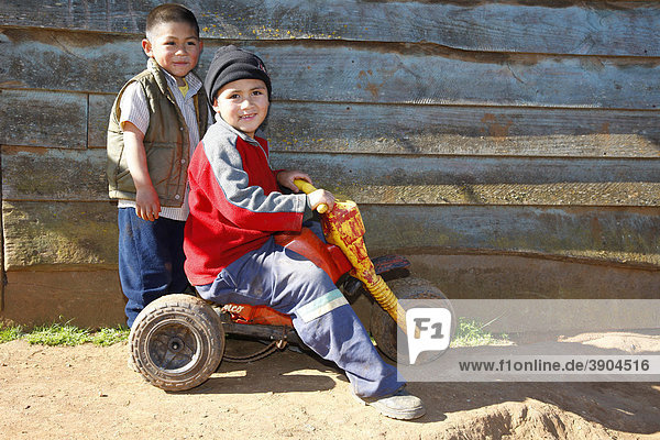 Two boys playing with a tricycle  Mapuche Indians  near ConcepciÛn  Southern Chile  Chile  South America