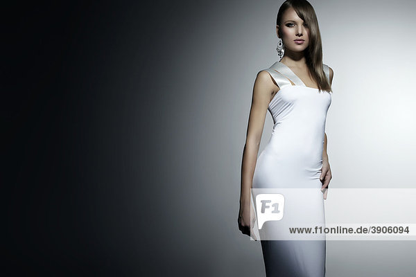 Junge Frau im weißen Kleid  Ohrring  direkter Blick  Fashion