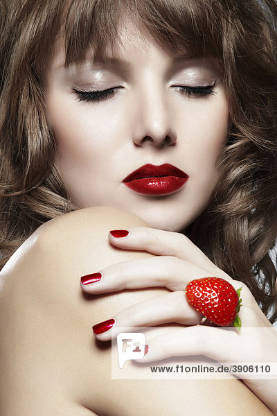Portrait einer jungen Frau mit einem Erdbeer-Ring  die Augen geschlossen  Schmuck