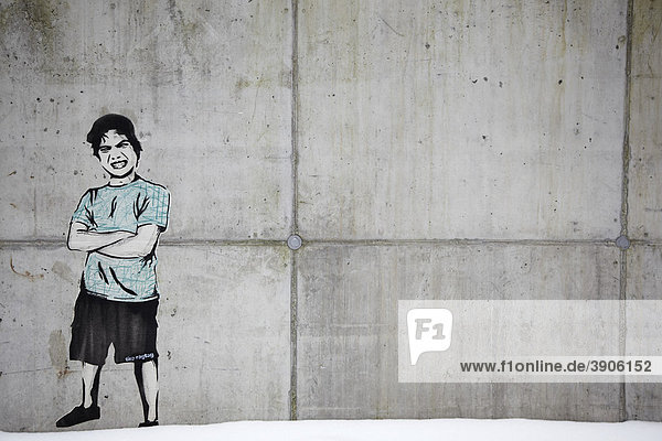 Graffiti auf einer Betonmauer  Junge in T-Shirt  kurzen Hosen  die Arme verschränkt