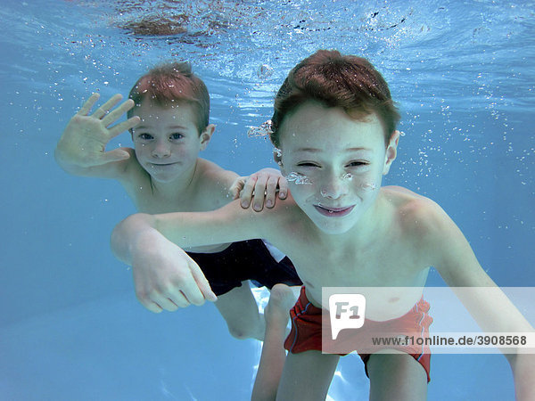 Two boys  6 and 7 years old  under water in a pool