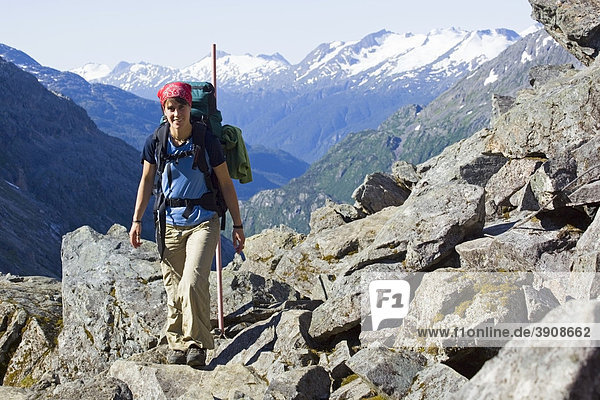 Young woman hiking up  backpacking  hiker  summit of legendary Golden Stairs of Chilkoot Trail  Pass  view into Taja River Valley  Klondike Gold Rush National Historical Park  Alaska  USA
