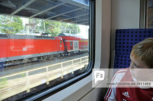 Achtjähriger Junge sitzt alleine in einem Regionalzug  Deutschland  Europa