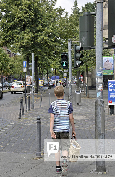 Neunjähriger Junge geht bei Grün über eine Straße  Deutschland  Europa