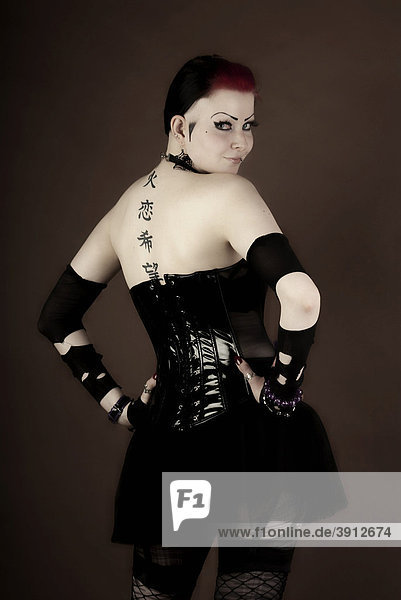 Woman  dressed in a Gothic style  with a tattooed back