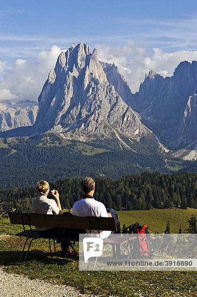 Hikers looking over the Seiser Alm on Mt. Sassolungo and Mt. Plattkofel  Dolomites  South Tyrol  Italy  Europe