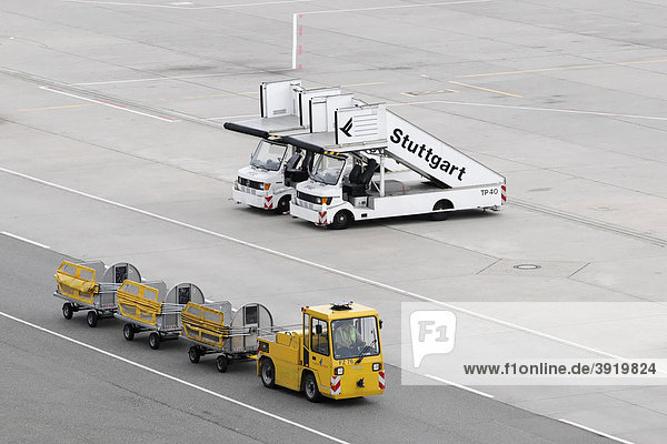 Airport vehicles  mobile steps and baggage trailer  Stuttgart Airport  Baden-Wuerttemberg  Germany  Europe