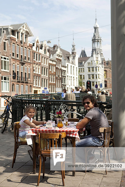 Touristenfamilie beim Mittagessen in einer Straße von Amsterdam  Holland  Niederlande  Europa