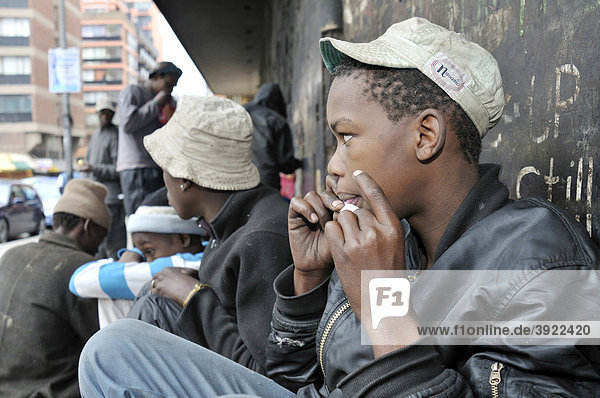 Street child consuming drugs  marijuana  boy making a joint  in Hillbrow  Johannesburg  South Africa  Africa