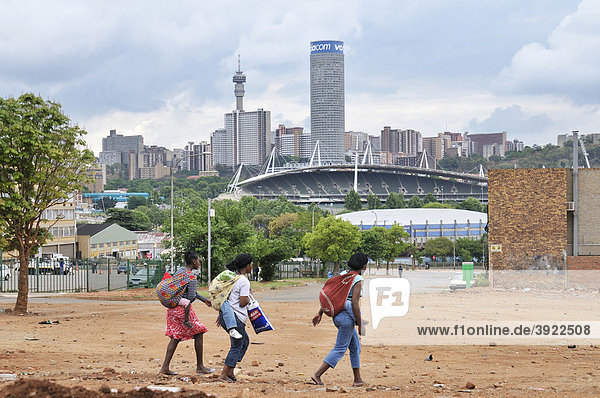 Drei jugendliche Mütter mit Kind auf dem Rücken  dahinter die Skyline von Johannesburg  Südafrika  Afrika
