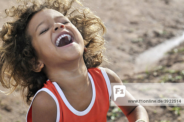 Happy girl laughing and dancing  landless camp Acampamento 12 de Otubro  Brazilian Landless Workers' Movement Movimento dos Trabalhadores Rurais sem Terra  MST  Munizip Claudia  Mato Grosso  Brazil  South America