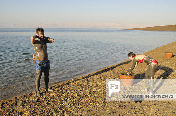 Touristen beschmieren sich mit salzhaltigem Schlick aus dem Toten Meer  bei Suwaymah  Jordanien  Naher Osten  Orient