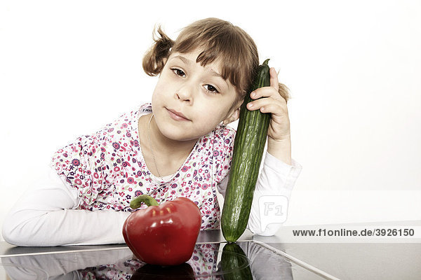 Six-year-old girl holding vegetables in hand