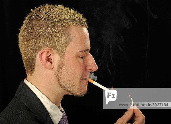 Junger Mann raucht Zigarette