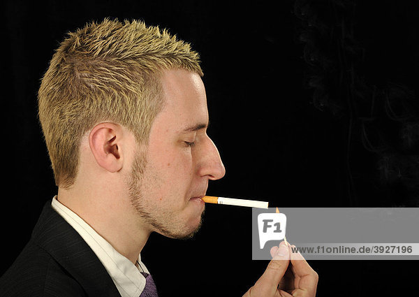 Junger Mann raucht Zigarette