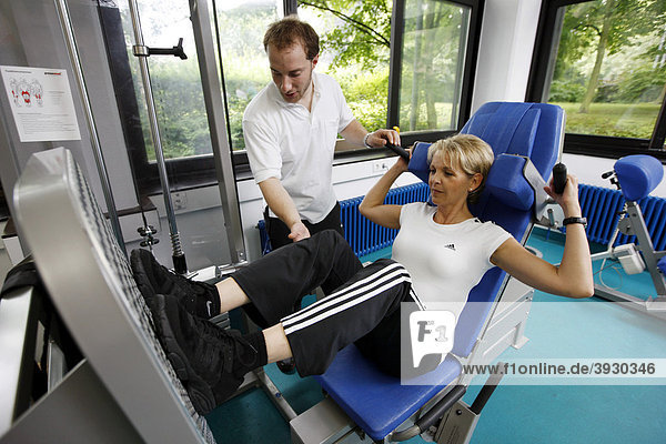 Patient during muscle strength training on a machine in the training room  physiotherapy in a neurological rehabilitation centre  Bonn  North Rhine-Westphalia  Germany  Europe