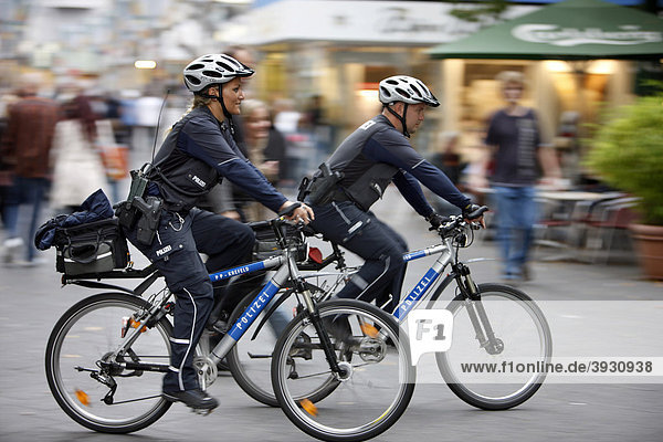 Bike police patrolling in a pedestrian zone  Germany  Europe