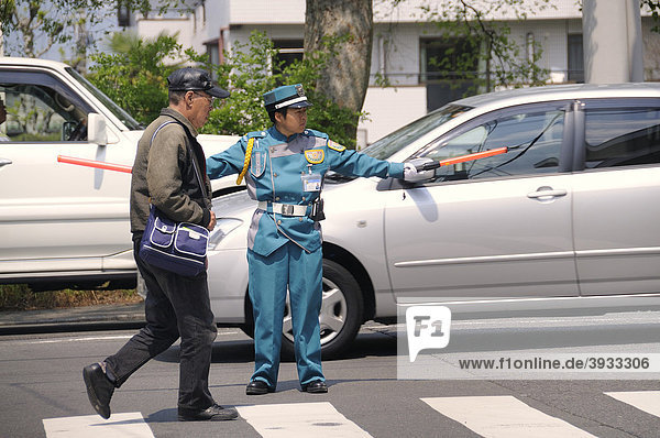 Typical police officer directing traffic in a parking lot  Kyoto  Japan  East Asia  Asia