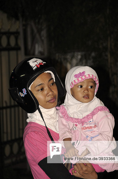 Javanerin mit Kopftuch  Moslemin  unter Schutzhelm  mit Baby  Yogjakart  Java  Indonesien  Südostasien