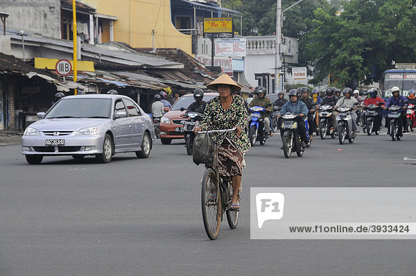 Contrast between modern and traditional transportation  motorcycle  bicycle in Yogjakarte  Central Java  Indonesia  Southeast Asia  Asia